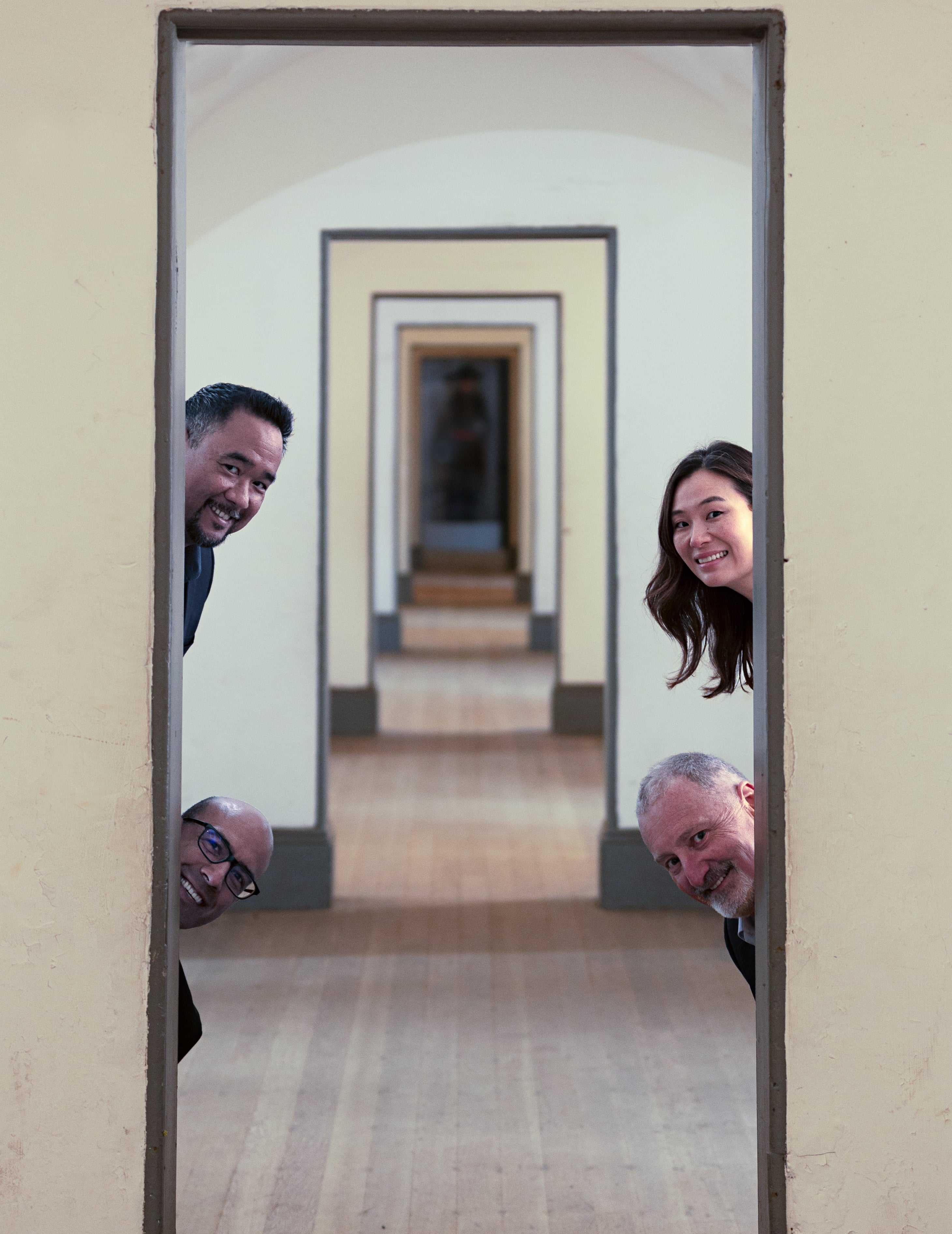 Alexander String Quartet looking through a doorway in a hallway
